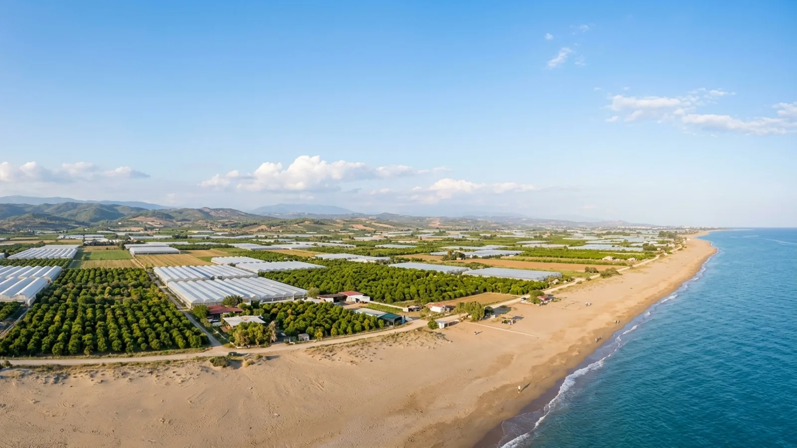 Kizilagac, Türkiye — the coastal plain at Kizilagac east of Side, a sandy beach and farmland of greenhouses and citrus groves behind it.
